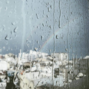 rain and rainbow outside a window