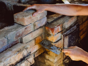 hands working on masonry restoration